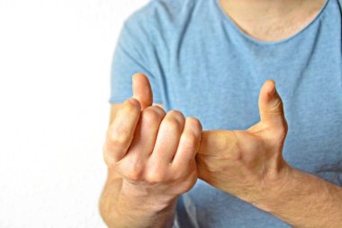 Genç bir adam avuçlarını bir araya getirir - farklı ülkelerde farklı anlamlara sahip bir jest, adamın ellerine odaklanarak 