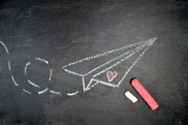 Bir tebeşir bir kağıt düzlem çizilmiş ve karanlık mermer bir yüzey üzerinde kesik bir yol çizilmiş - uçan bir kağıt uçak ile arka plan