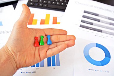 Genç bir adam, istatistik rakamları bakarak, elinde bir büyüteç tutuyor-örnekleme ve doğru hedef grubu seçerek ve onu inceleyerek konu üzerinde bir iş kavramı 