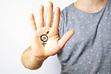 Onun orta yirmili bir adam elinde cinsiyet eşitliği bir işareti boyalı ve kamera gösterir-erkek ve kadınlar arasında eşitlik talep için bir kavram