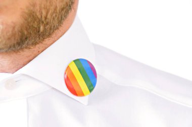 20'li yaşlarının ortasında bir adam takım ceketinde transseksüel sembolü olan bir düğme takıyor - Çalışma Hayatında Kabul ve Hoşgörü Kavramı