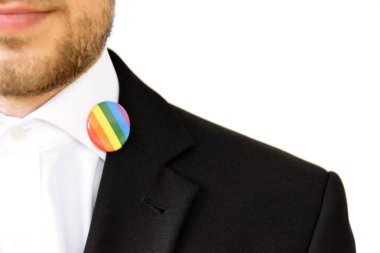 20'li yaşlarının ortasında bir adam takım ceketinde transseksüel sembolü olan bir düğme takıyor - Çalışma Hayatında Kabul ve Hoşgörü Kavramı