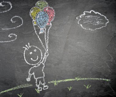 Koyu taş yüzeyde tebeşir ile boyanmış balonlar olan küçük bir çocuk-yere balonlar ile uçan bir çocuk 