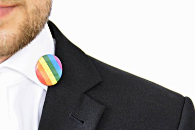 20'li yaşlarının ortasında bir adam takım ceketinde transseksüel sembolü olan bir düğme takıyor - Çalışma Hayatında Kabul ve Hoşgörü Kavramı