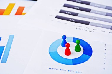 Genç bir adam, istatistik rakamları bakarak, elinde bir büyüteç tutuyor-örnekleme ve doğru hedef grubu seçerek ve onu inceleyerek konu üzerinde bir iş kavramı 