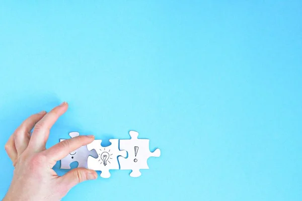 Bir yüz, bir soru işareti, bir ünlem işareti diğeri üzerinde bulmaca parçaları vardır. Bir el bir ampul puzzle parçası ile bu iki parça bağlanır. Konsept alan ile oluşturmak için 