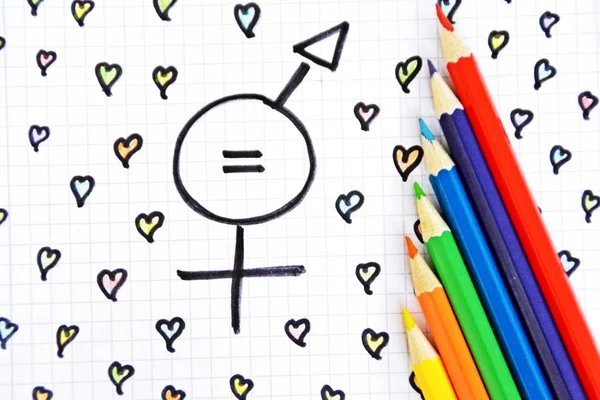 A sign for the equality of man and woman consisting of the respective gender signs and a match with painted hearts and colored pencils on a drawn sheet -equality man and woman symbolically represented