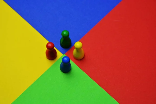 異なる色の小さな男性が同じ色の表面に立っている ゲームのフィギュア 色とチームの多様性を表すために これらの会議との概念 — ストック写真