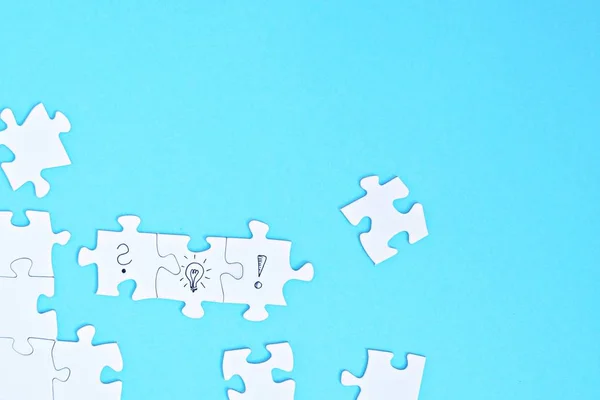 Bir yüz, bir soru işareti, bir ünlem işareti diğeri üzerinde bulmaca parçaları vardır. Bir el bir ampul puzzle parçası ile bu iki parça bağlanır. Konsept alan ile oluşturmak için 