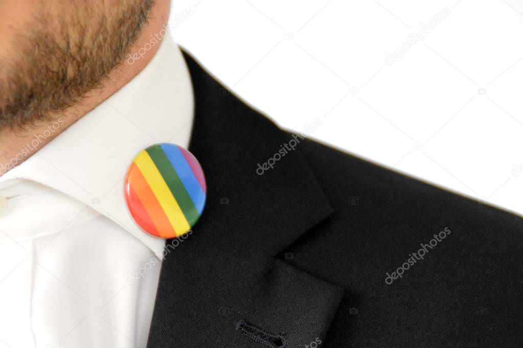 A man in his mid-twenties wears a button with the symbol for transgender on his suit jacket - Concept for Acceptance and Tolerance in Working Life