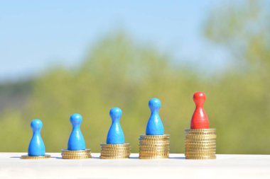  sikke farklı yüksekliklerde yığılmış, yükselen bir kulak sonuçlanan. Her yığını üzerinde evler ve bir oyun figürü finansmanı sembolize bir ev standları-metin için oda ile