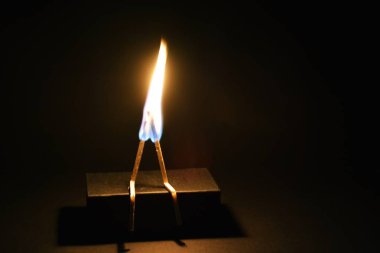 İki erkek oturuyormuş gibi görünüyor, böylece ikisi maç ile sevgi dolu çiftler için kavramı yanık olarak diğerlerine karşı eğiliyor, bir maç, böylece bükülmüş 