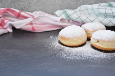 Geleneksel karnaval sezonu nda Almanya'da pişmiş sözde Krapfen, karanlık bir yüzey üzerinde yalan - çörekler pudra şekeri serpilir 