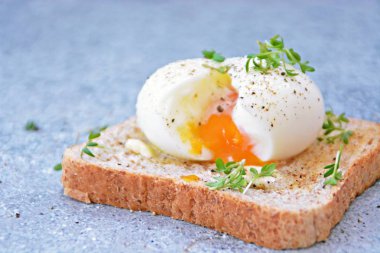 Taze kavrulmuş tüm buğday tost üzerinde yumurta akan yumuşak yumurta sarısı ile haşlanmış bir yumurtadır. Yumurta üzerinde Cress ve tuz ve biber 