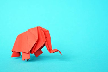 Açık mavi bir arka plan karşı kırmızı kağıttan katlanmış bir origami fil