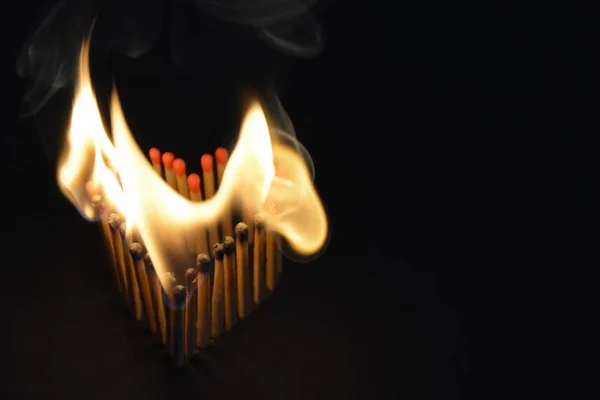 火柴粘在黑暗的区域 有心脏的形状 因为他们燃烧着明亮的火焰 一个燃烧的爱和热欲望的概念 — 图库照片