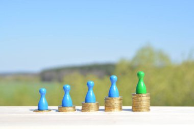  sikke farklı yüksekliklerde yığılmış, yükselen bir kulak sonuçlanan. Her yığını üzerinde evler ve bir oyun figürü finansmanı sembolize bir ev standları-metin için oda ile