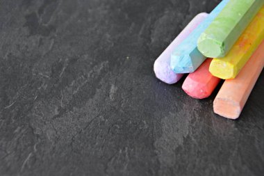 Farklı renkli tebeşir koyu mermer yüzey üzerinde yalan - renkli tebeşir ve metin veya diğer öğeler için yer ile bir arka plan olarak kavram 