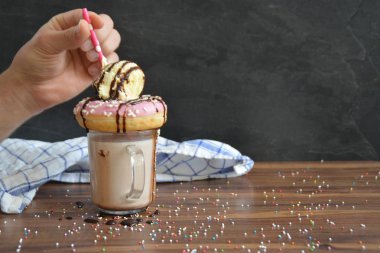 Bir bardak çikolatalı süt, bir çörek ve dondurma bir kepçe ile yığılmış-kavramı tatlı milkshake ile 