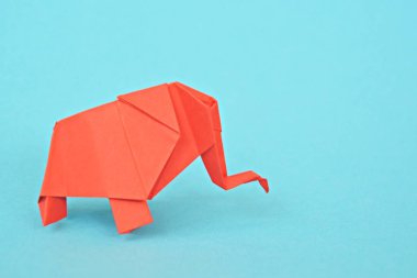 Açık mavi bir arka plan karşı kırmızı kağıttan katlanmış bir origami fil