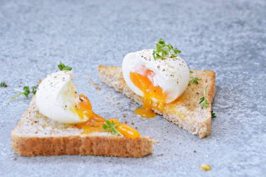 Taze kavrulmuş tüm buğday tost üzerinde yumurta akan yumuşak yumurta sarısı ile haşlanmış bir yumurtadır. Yumurta üzerinde Cress ve tuz ve biber 