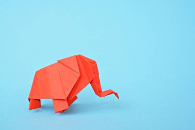 Açık mavi bir arka plan karşı kırmızı kağıttan katlanmış bir origami fil