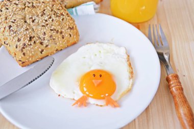 Kızarmış yumurta bir tabak üzerinde yatıyor, yanında ekmek ve çatal bıçak takımı vardır. Kızarmış dondurma yumurta sarısı bir civciv gibi görünüyor, göz iki tane ve ağız ve ayak olarak havuç parçaları ile