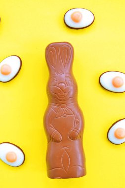 Bir Paskalya tavşanı dışında renkli çikolata parçaları ile çikolata yapılmış tek amaçlı bir yüzey üzerinde yatıyor - renkli bir yüzeyüzerinde tatlılar paskalya