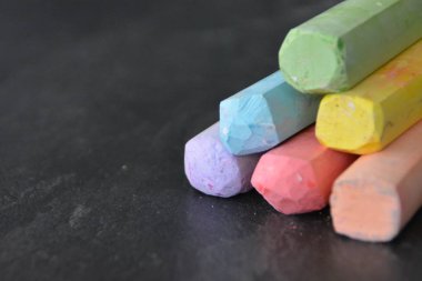 Farklı renkli tebeşir koyu mermer yüzey üzerinde yalan - renkli tebeşir ve metin veya diğer öğeler için yer ile bir arka plan olarak kavram 