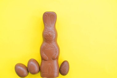 Bir Paskalya tavşanı dışında renkli çikolata parçaları ile çikolata yapılmış tek amaçlı bir yüzey üzerinde yatıyor - renkli bir yüzeyüzerinde tatlılar paskalya