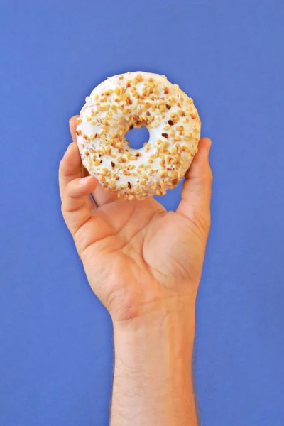 Hand Håller Munk Med Choklad Glasyr Uppåt Bakgrunden Färgad Och — Stockfoto