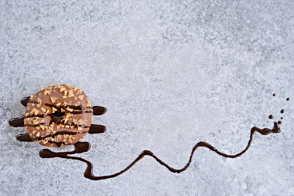 Ένα Ντόνατ Γλάσο Σοκολάτας Και Καραμέλες Καραμέλας Βρίσκεται Μια Γκρίζα — Φωτογραφία Αρχείου