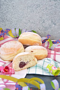 Karnaval sezonu nda Almanya'da pişirilen geleneksel çörekler bir tabak üzerinde yatıyor ve pudra şekeri serpilir - Almanya'da karnaval zamanında Krapfen denilen bir kavram 