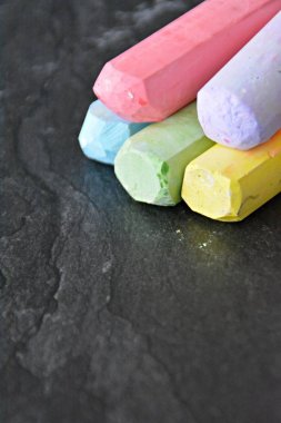 Farklı renkli tebeşir koyu mermer yüzey üzerinde yalan - renkli tebeşir ve metin veya diğer öğeler için yer ile bir arka plan olarak kavram 