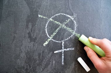 Kadın için sembol koyu mermer bir yüzeye boyanmış ve bir kanca yeşil ile boyanmıştır - Kadın oy hakkı için kavram 