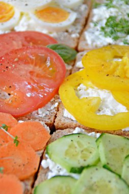 Farklı Topingler ile birçok bütün tahıl tost, arka plan olarak bir kepekli tost ve kaba taneli krem peynir üzerinde sebze ile sağlıklı beslenme için karanlık bir yüzey-konsept yalan