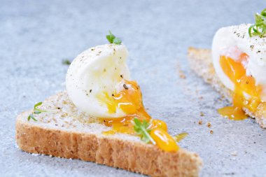 Taze kavrulmuş tüm buğday tost üzerinde yumurta akan yumuşak yumurta sarısı ile haşlanmış bir yumurtadır. Yumurta üzerinde Cress ve tuz ve biber 