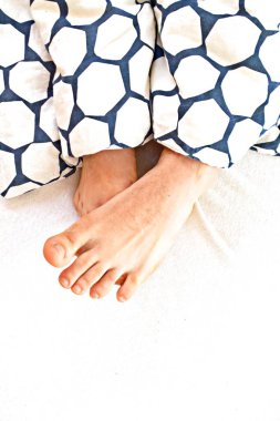 yataktan çıkan bacakların yakın çekim görünümü