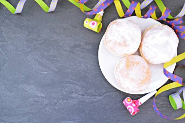 Karnaval sezonu nda Almanya'da pişirilen geleneksel çörekler bir tabak üzerinde yatıyor ve pudra şekeri serpilir - Almanya'da karnaval zamanında Krapfen denilen bir kavram -