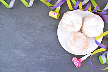 Traditional donuts baked in Germany during the carnival season lie on a plate and are sprinkled with powdered sugar - a concept with so-called Krapfen at carnival time in Germany - clipart