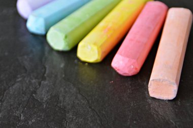 Farklı renkli tebeşir koyu mermer yüzey üzerinde yalan - renkli tebeşir ve metin veya diğer öğeler için yer ile bir arka plan olarak kavram 