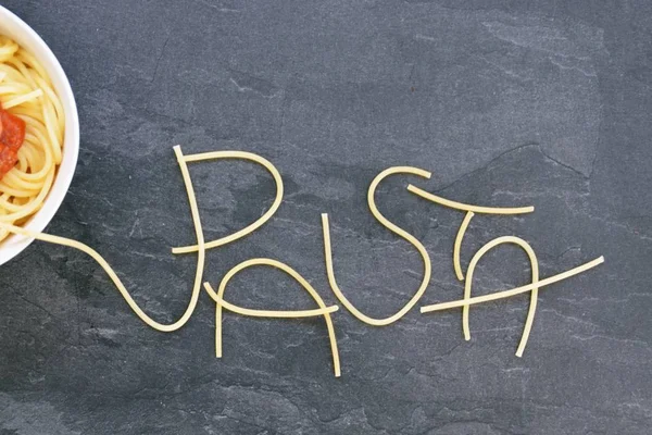 Con Espaguetis Palabra Pasta Estaba Escrita Una Superficie Mármol Oscuro —  Fotos de Stock
