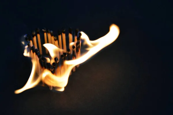 火柴粘在黑暗的区域 有心脏的形状 因为他们燃烧着明亮的火焰 一个燃烧的爱和热欲望的概念 — 图库照片