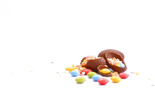 Fragmenterne Chokoladepåskeæg Ligger Hvid Overflade Fyldt Med Farverig Chokolade Konfetti - Stock-foto