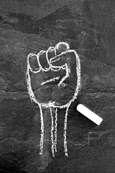 チョークで伸ばされた拳は暗い大理石の表面に描かれた 革命のシンボルとチョークで描かれたデモンストレーション — ストック写真