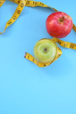 Sarı bir ölçüm bandı beyaz bir arka plan önünde, bir elma etrafında sarılmış oldu - diyet ve metin veya diğer unsurlar için alan ile sağlık nedeniyle zayıflama kavramı 
