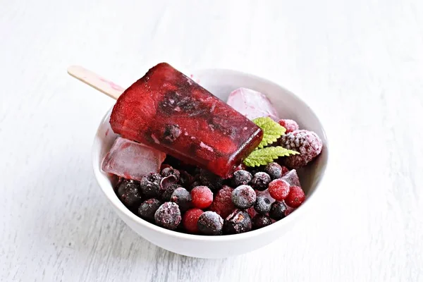 Homemade popsicles of wild berries with berries and mint leaves - refreshing healthy organic ice