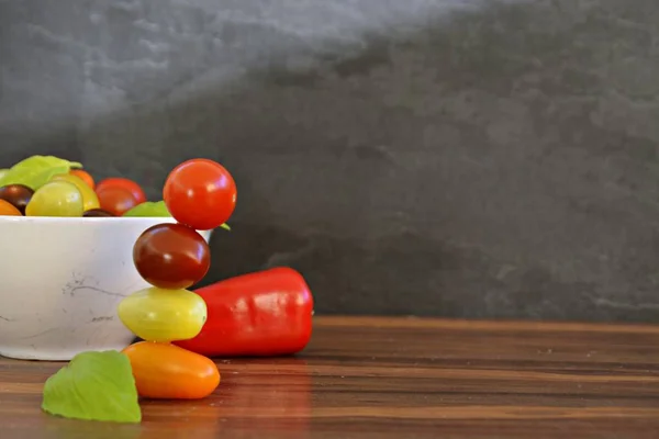 Different types of tomatoes in different colors and basil - concept with fresh and healthy different tomatoes, with space for text for other elements