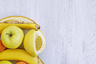 Elma, armut ve muz gibi sarı meyve bir demet düz bir yüzey üzerinde yalan, bir bıçak ile bir kare çerçeve meyve içine kesildi - mükemmel bir çerçeve olarak düzenlenmiş meyve