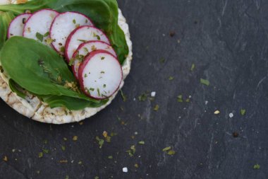 Koyu mermer bir yüzey üzerinde üç yuvarlak pirinç waffle, marul ve turp ve metin veya diğer unsurlar için alan ile sarı bir bant ölçüsü ile - spor salonunda sağlıklı beslenme için kavram